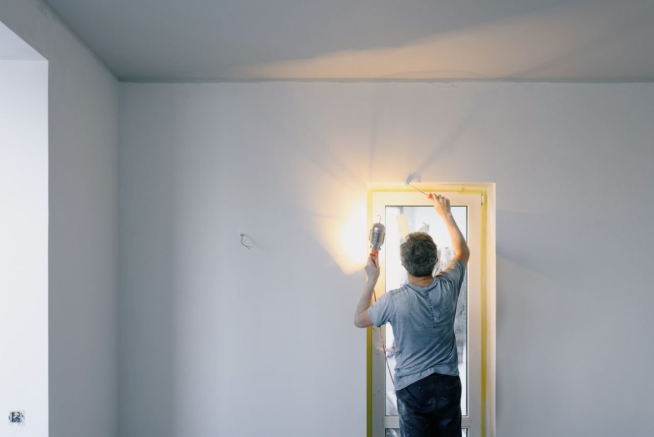 The Art of Drawing Readers In: Your attractive post title goes here Back view of unrecognizable male in dirty clothes holding bright lamp while repairing door at home