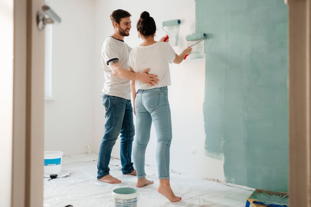 Crafting Captivating Headlines: Your awesome post title goes here A couple painting a room together, focusing on home renovation and bonding.